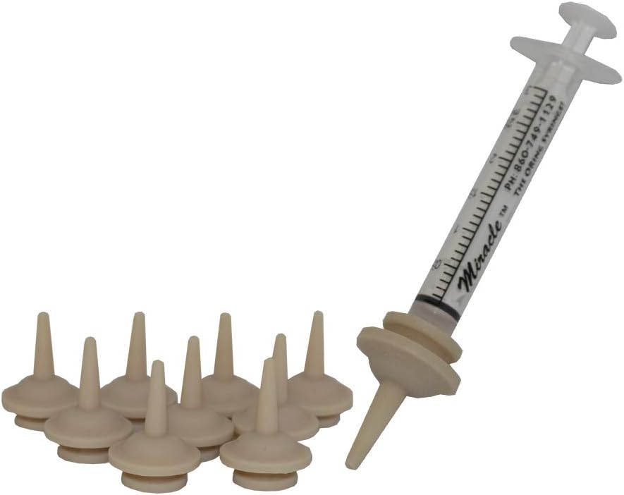 Clear feeding syringe with attached Miracle Nipple and several extra beige silicone nipples on a white background