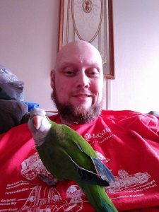 Chris Box With Benji The Parrot In Relaxed Indoor Portrait